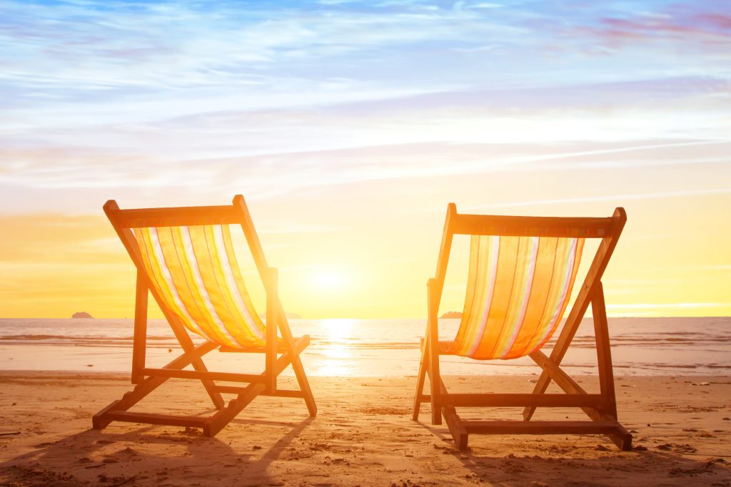 Two empty deck chairs on the beach